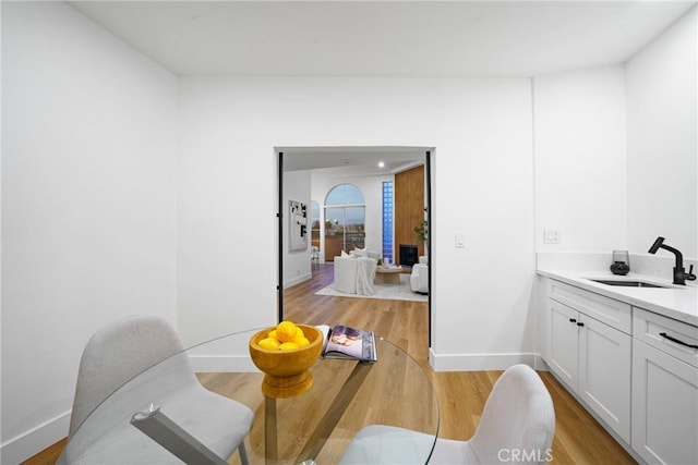 dining area featuring sink and light hardwood / wood-style flooring