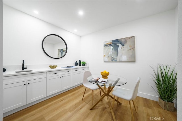 dining area with light hardwood / wood-style flooring and sink