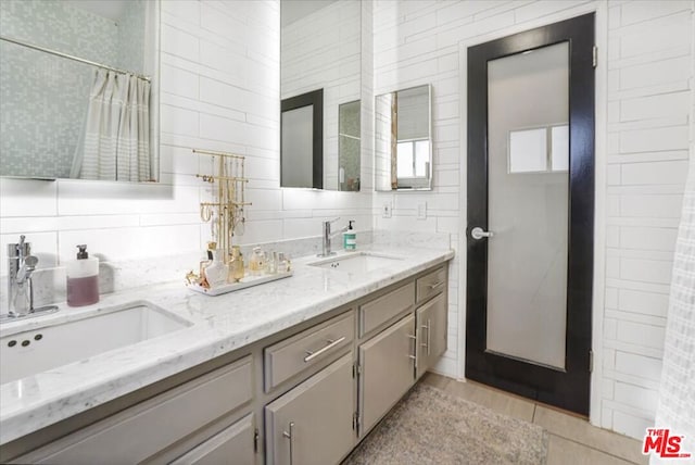 bathroom featuring a shower with shower curtain, tile patterned floors, backsplash, and vanity