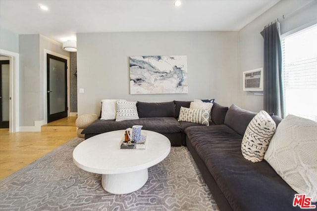 living room featuring a wall unit AC and hardwood / wood-style floors