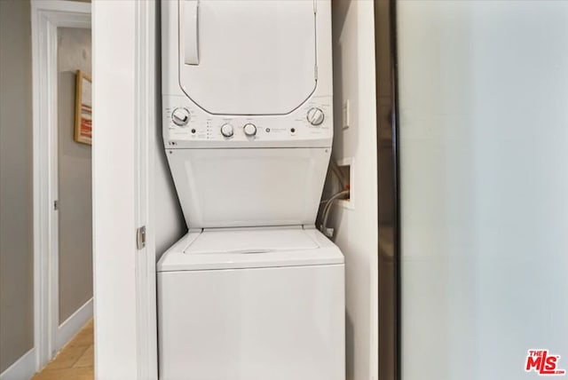 clothes washing area featuring stacked washer and clothes dryer