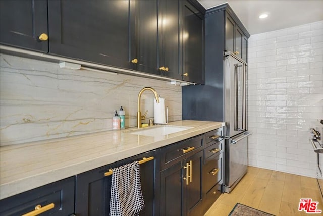 kitchen featuring light stone countertops, sink, and light hardwood / wood-style floors