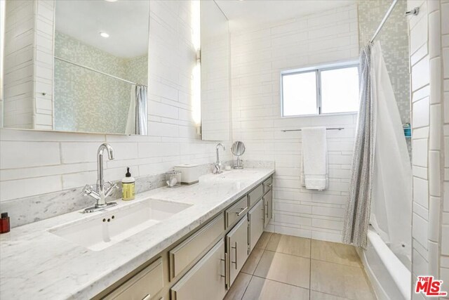 bathroom with shower / bath combo with shower curtain, vanity, and tile patterned flooring