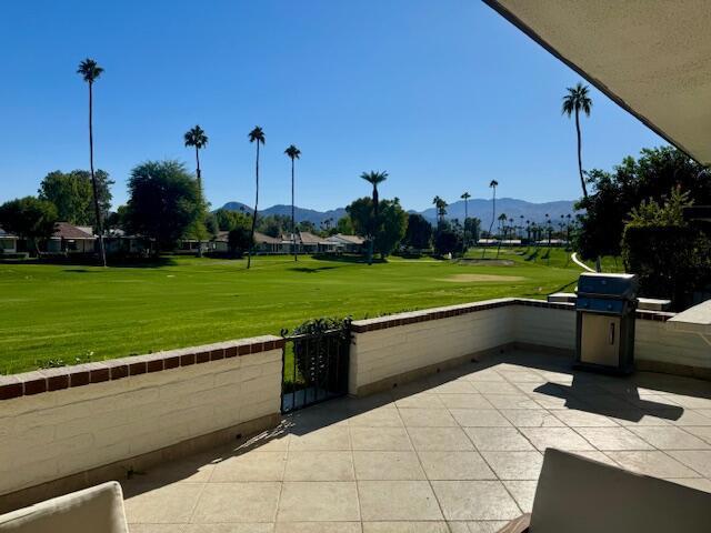 view of property's community with a patio area, a mountain view, and a yard