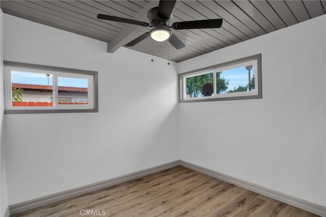 spare room with wood ceiling, ceiling fan, light wood-type flooring, and beam ceiling