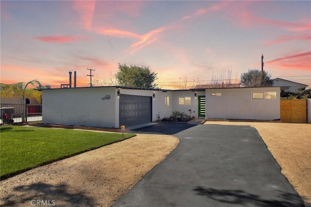 single story home with a garage and a lawn