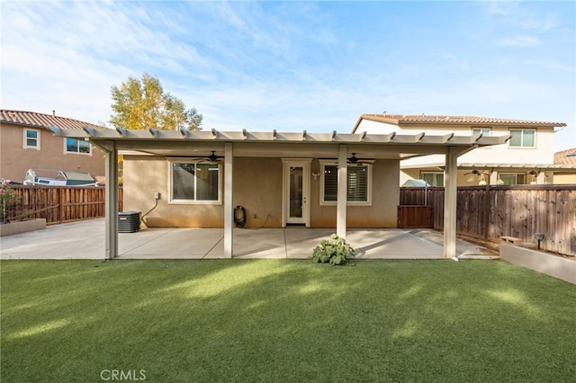 rear view of house with ceiling fan, a lawn, and a patio