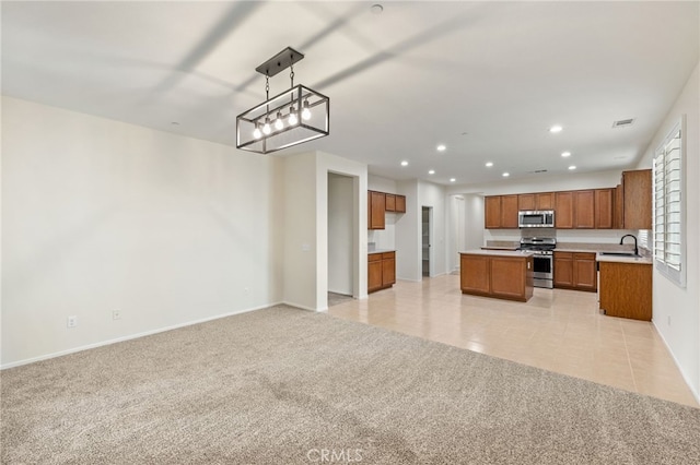 kitchen featuring a kitchen island, sink, light tile patterned flooring, hanging light fixtures, and appliances with stainless steel finishes