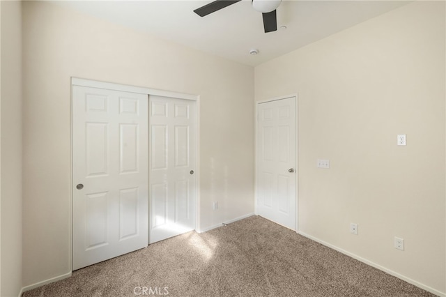 unfurnished bedroom featuring ceiling fan, a closet, and carpet flooring