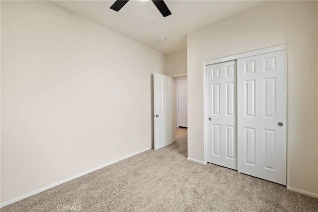 unfurnished bedroom featuring ceiling fan, a closet, and light colored carpet