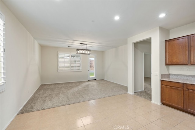 unfurnished dining area with light colored carpet