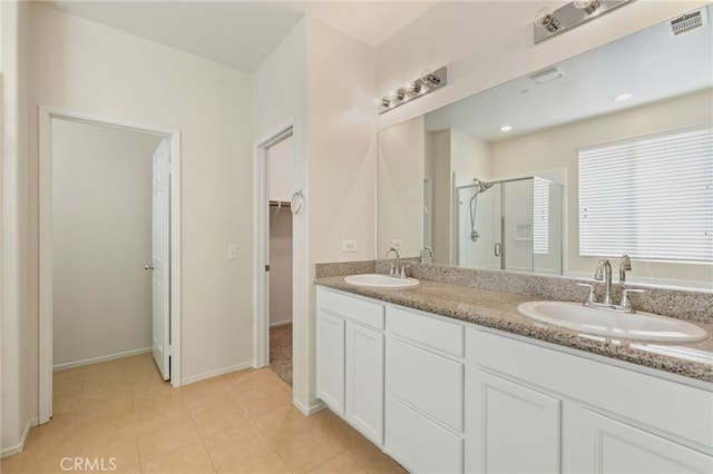 bathroom featuring tile patterned flooring, a shower with shower door, and vanity