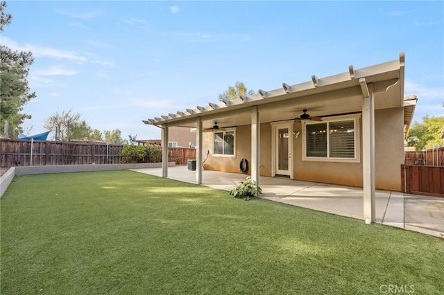 back of property featuring ceiling fan, a patio area, and a lawn