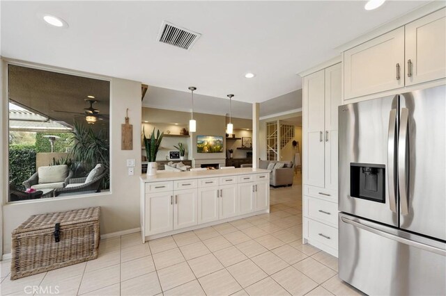 kitchen with white cabinetry, stainless steel fridge, decorative light fixtures, and light tile patterned flooring