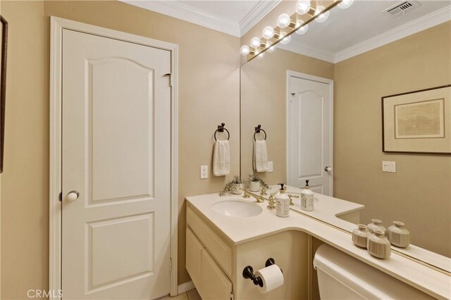 bathroom with crown molding, vanity, and toilet