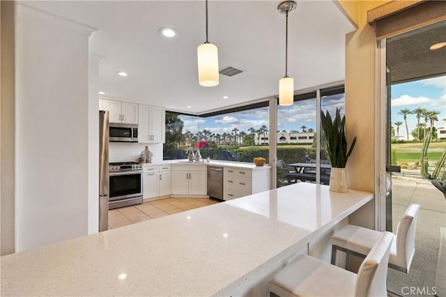 28 Pebble Beach Dr, Rancho Mirage, CA 92270 - kitchen featuring appliances with stainless steel finishes, white cabinetry, a sink, light tile patterned floors, and light stone counters