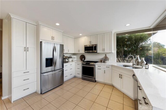 kitchen featuring white cabinetry, sink, light tile patterned flooring, and appliances with stainless steel finishes