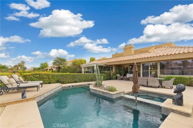 back of property with a patio and a pool with hot tub