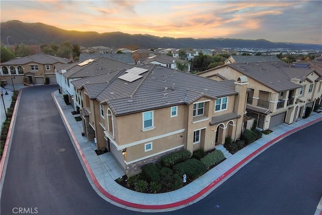 aerial view at dusk featuring a mountain view