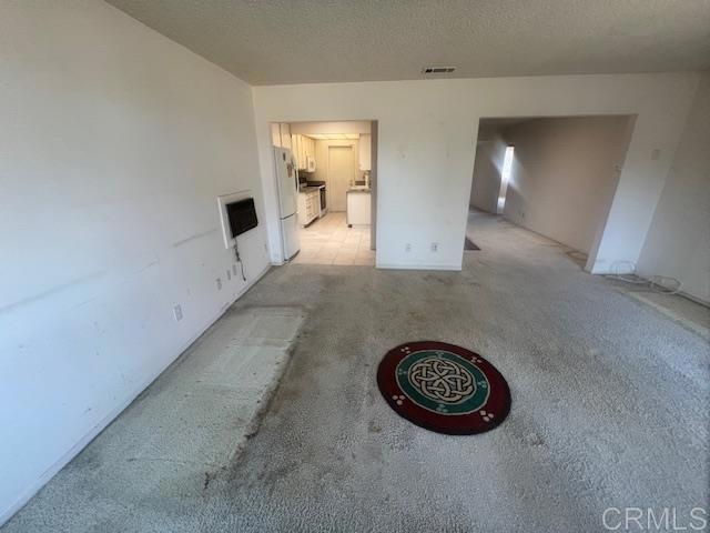 unfurnished room with a textured ceiling