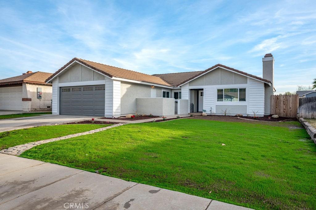 ranch-style house featuring a front lawn and a garage