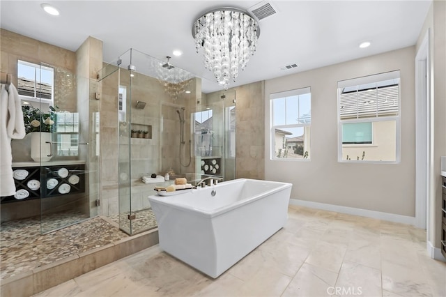 bathroom with a healthy amount of sunlight, separate shower and tub, vanity, and a notable chandelier