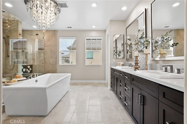 bathroom featuring vanity, a notable chandelier, and separate shower and tub