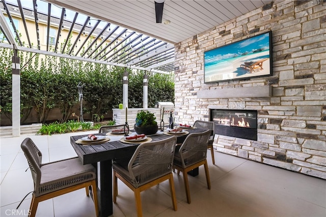 view of patio / terrace with an outdoor stone fireplace and a pergola