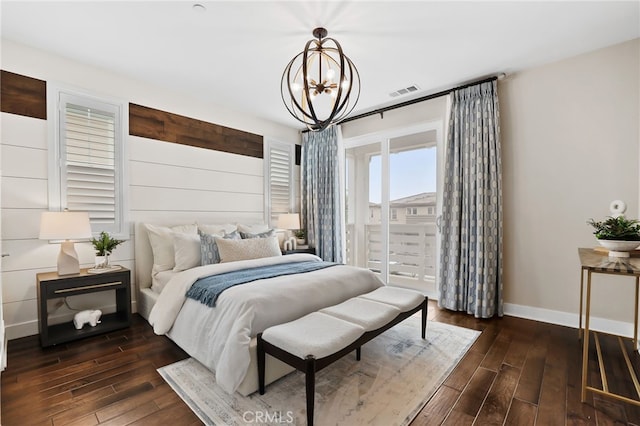 bedroom featuring access to exterior and a chandelier