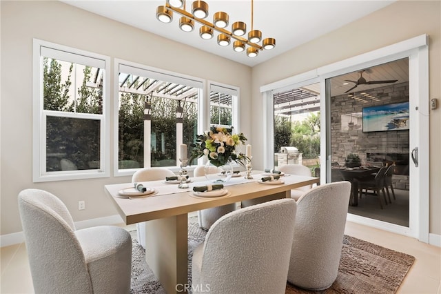 dining area with ceiling fan with notable chandelier and plenty of natural light