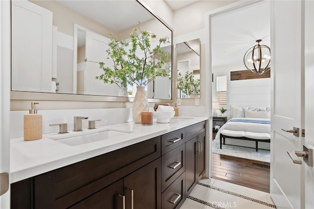 bathroom with an inviting chandelier, tile patterned floors, and vanity