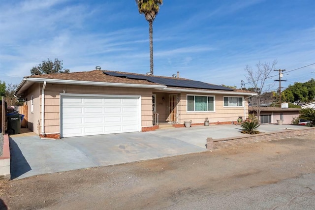 single story home featuring solar panels and a garage