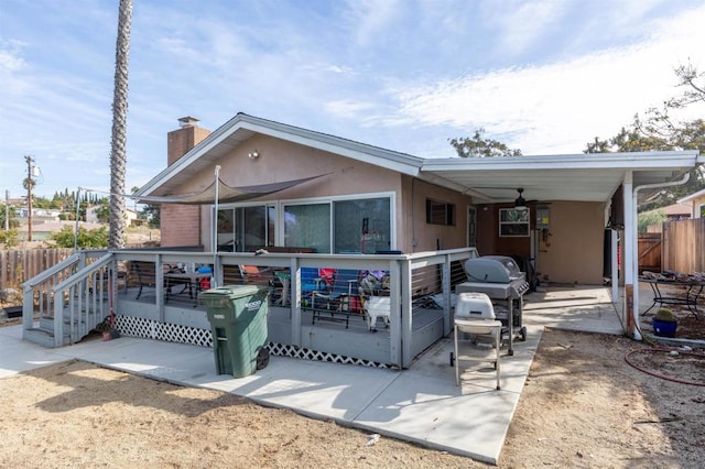 rear view of house featuring ceiling fan and a patio area