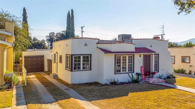 view of front of property featuring a garage and central AC unit