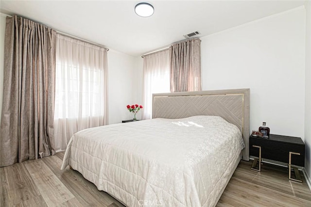 bedroom featuring multiple windows and hardwood / wood-style floors