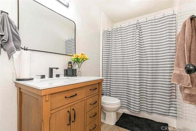 bathroom featuring toilet, vanity, walk in shower, and tasteful backsplash