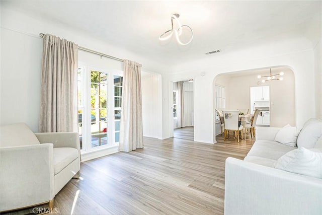 living room with a chandelier and light hardwood / wood-style floors