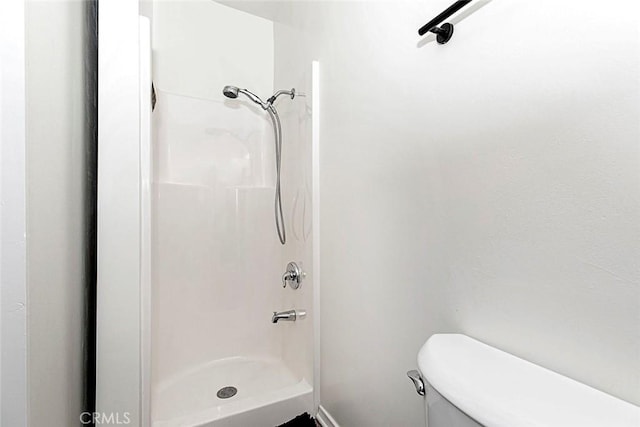 bathroom with a shower and toilet