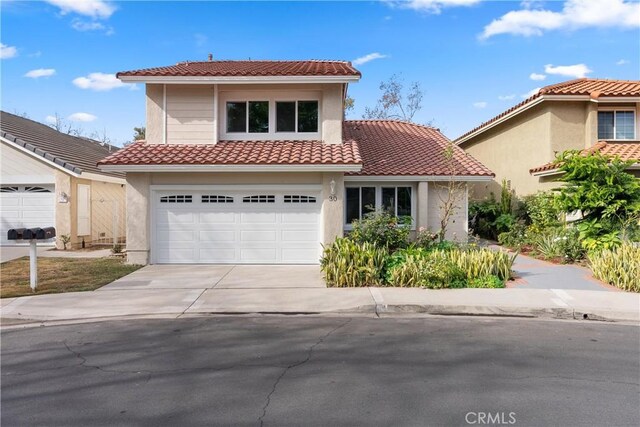 mediterranean / spanish home featuring a garage