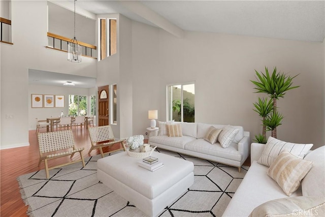 living room featuring high vaulted ceiling, light hardwood / wood-style flooring, beam ceiling, and a chandelier