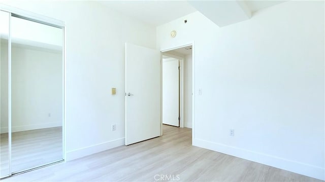 unfurnished bedroom featuring a closet and light hardwood / wood-style floors