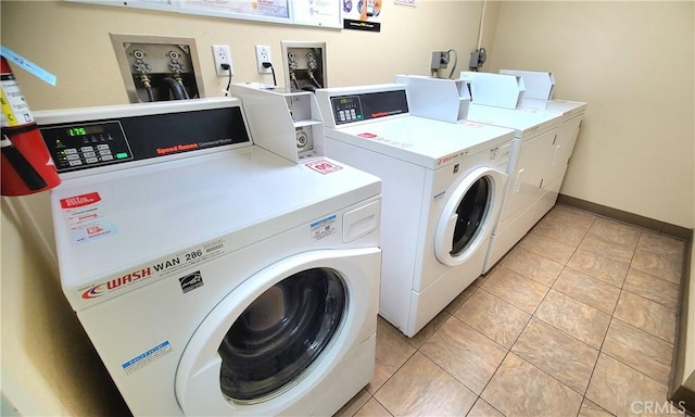 washroom with light tile patterned floors and washer and dryer