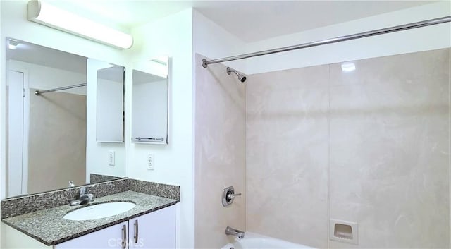 bathroom featuring washtub / shower combination and vanity