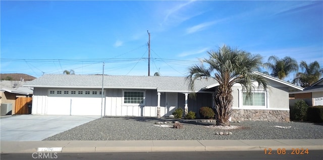 single story home with central air condition unit and a garage