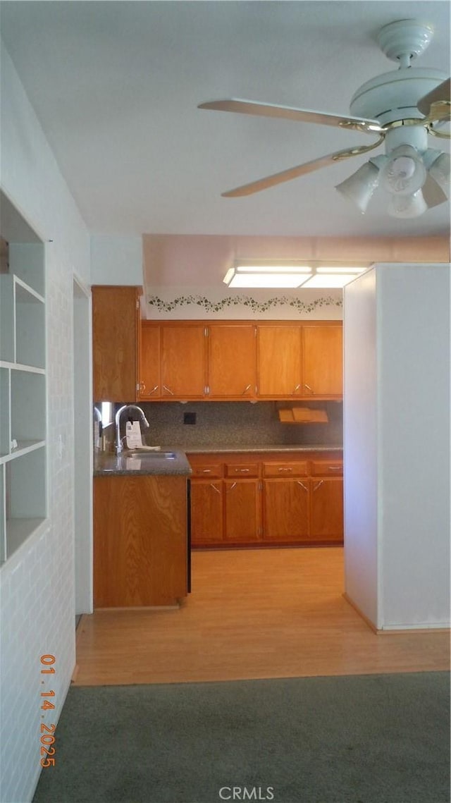 kitchen featuring ceiling fan, light wood-type flooring, sink, and tasteful backsplash