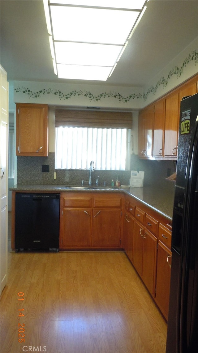 kitchen featuring light wood-type flooring, sink, and black appliances