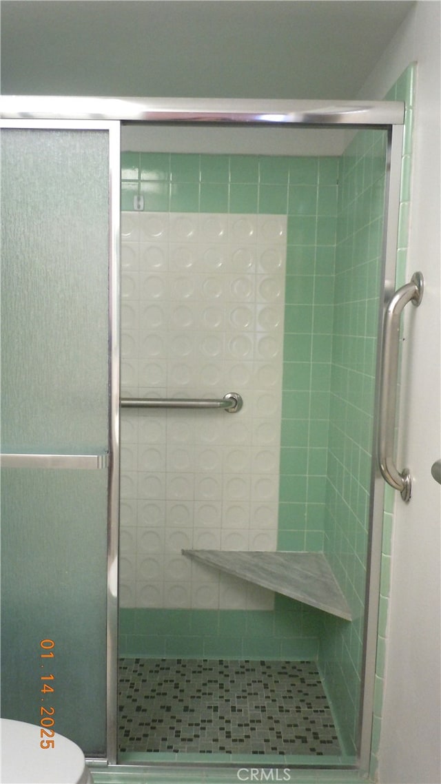 bathroom with an enclosed shower and toilet