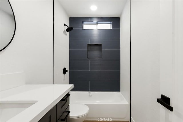 full bathroom featuring toilet, tiled shower / bath, and vanity