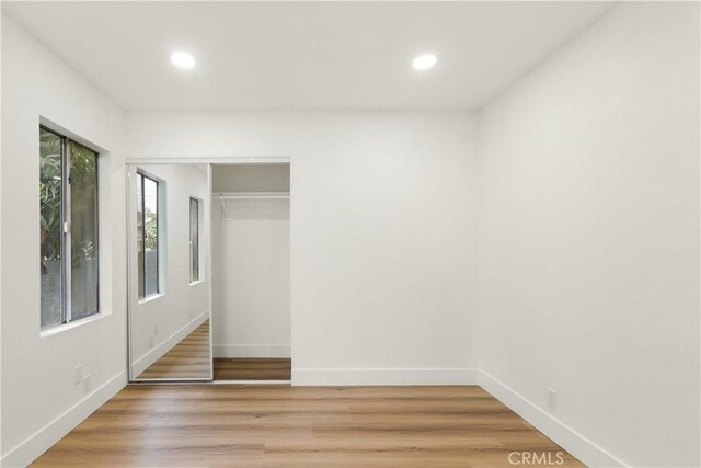 unfurnished bedroom featuring light hardwood / wood-style floors and a closet