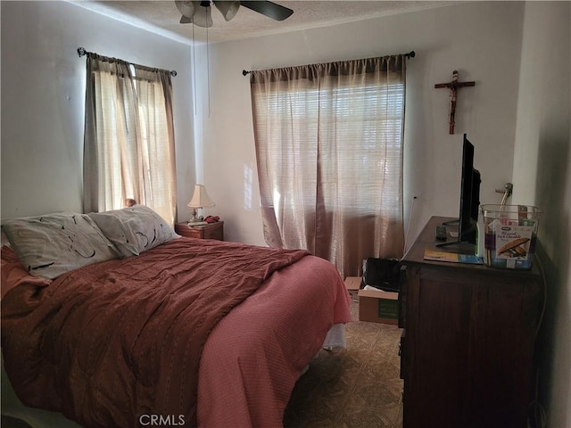 bedroom with ceiling fan and multiple windows